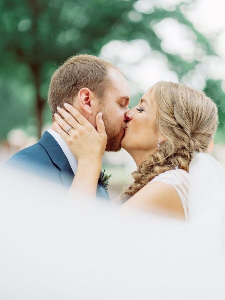 groom and bride with veil kiss