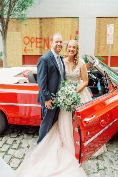 newlyweds in red getaway car
